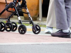 ベビーカーを押して歩く産後のママの足元とスニーカー