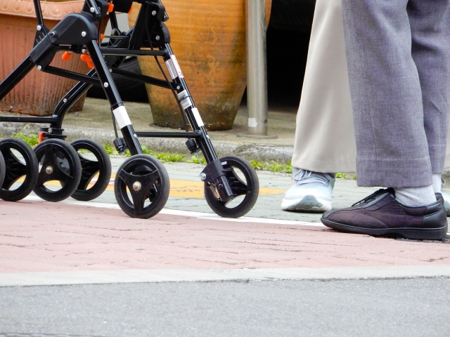 ベビーカーを押して歩く産後のママの足元とスニーカー